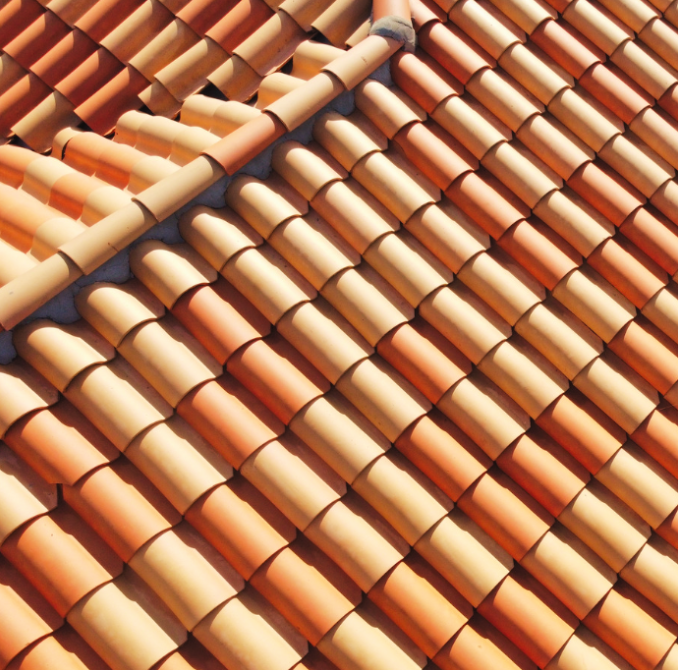 An image of a tile roof that has been cleaned using pressure washing methods, resulting in a brand new appearance. The tiles are evenly spaced and colored, and there are no visible signs of dirt, debris, or discoloration. The roof is shiny and reflects the sunlight.